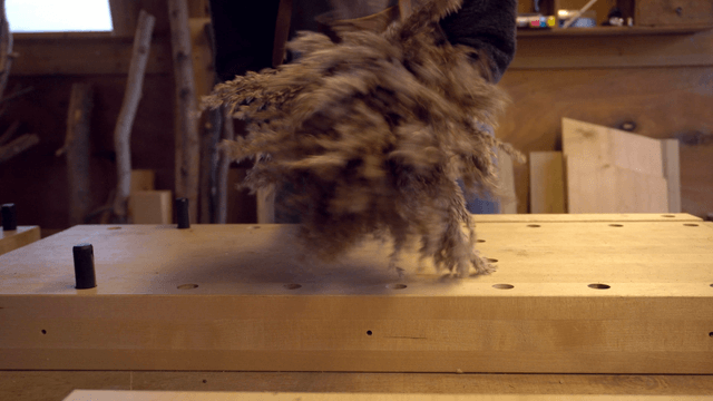 Person crafting with dried plants indoors