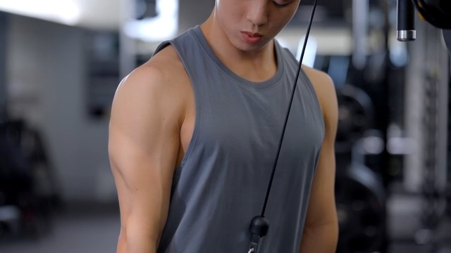 Man exercising with cable machine in gym