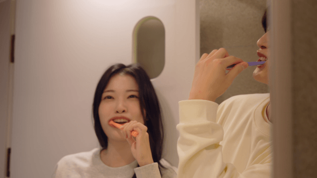 Affectionate couple brushing teeth playfully together