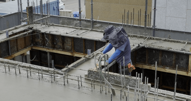 Construction workers leveling wet concrete