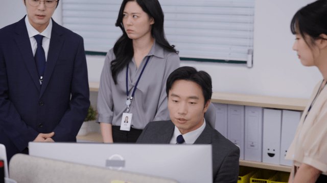 Office workers gathered around a desk, being scolded