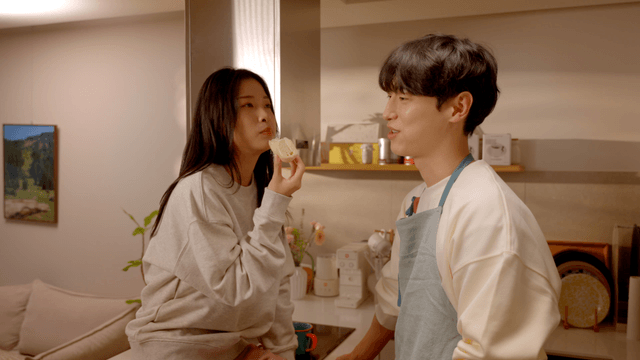 Happy couple talking while sharing bread in kitchen