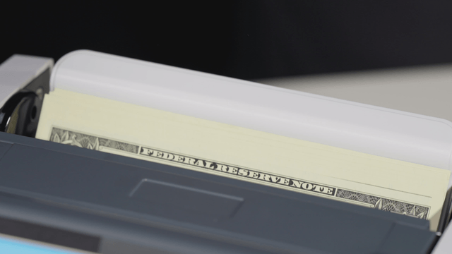Counting machine processing dollar bills
