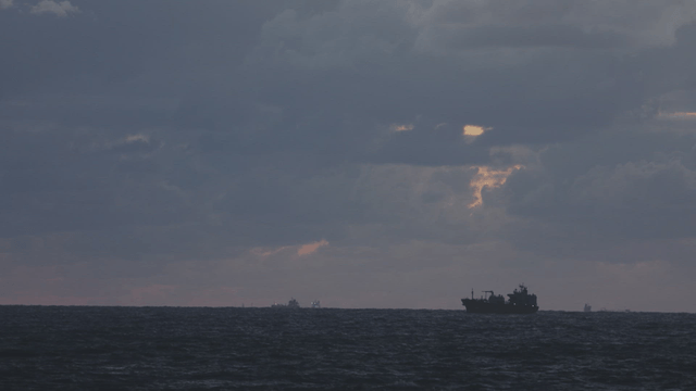 A ship sailing under a cloudy sky