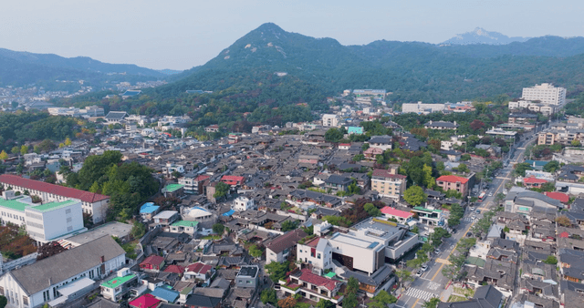 Traditional hanok village with distant mountain view