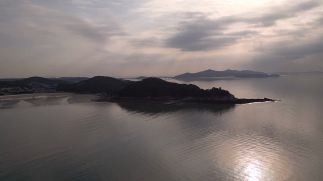 A serene coastal landscape at sunset