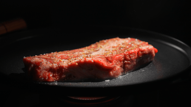 Steak sizzling on a hot pan