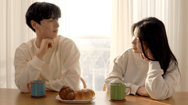 Couple talking at table with bread and coffee