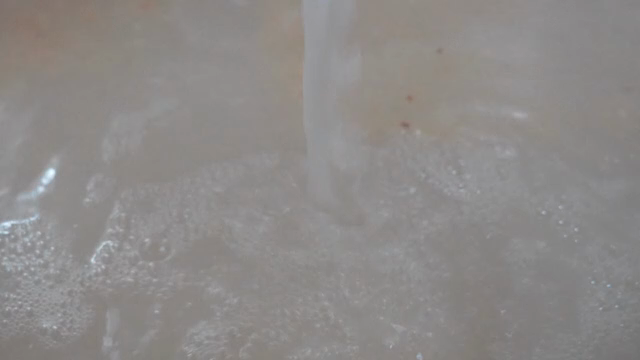 White liquid being poured into a pot
