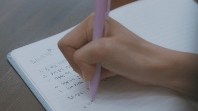 Person writing notes in a notebook