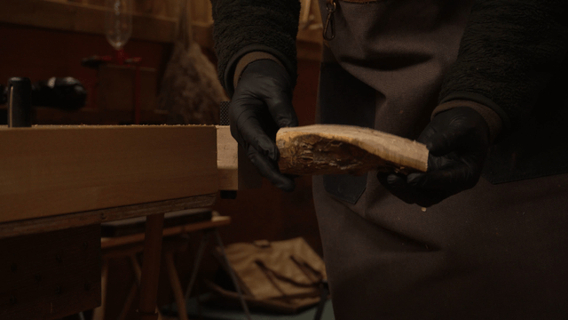 Woodcraft artisan examining wood in a cozy workshop
