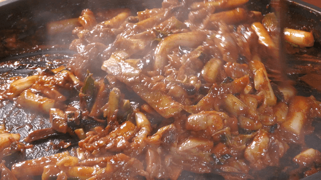 Spicy stir-fried chicken cooking in a pan