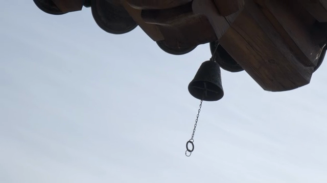 A bell hanging from a traditional Korean eaves