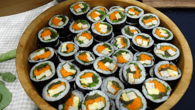 Kimbap neatly arranged in a wooden container