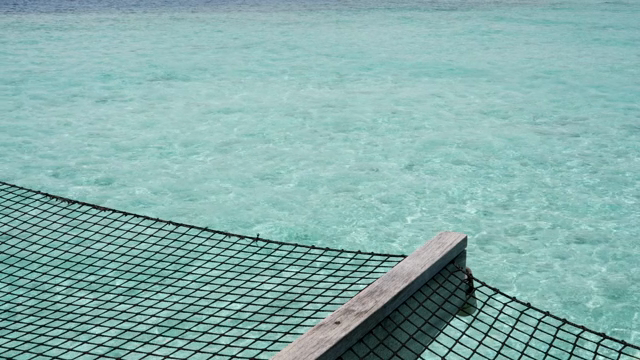 Clear turquoise sea with a netted deck