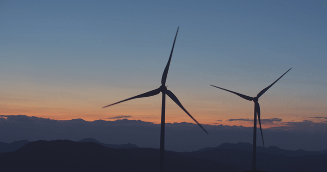 산속 일몰의 천천히 돌아가는 풍력 터빈