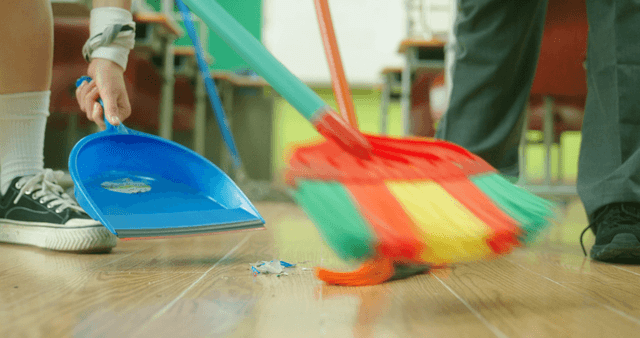 Cleaning the classroom floor with brooms