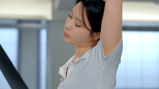 Woman stretching on a treadmill at gym