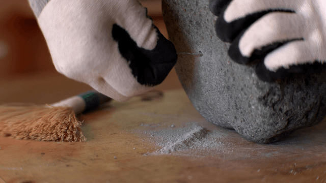 Hand cleaning a hole in a stone sculpture using wire