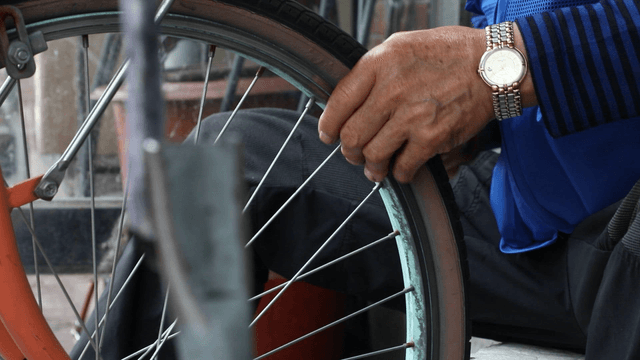 Person repairing a bicycle wheel