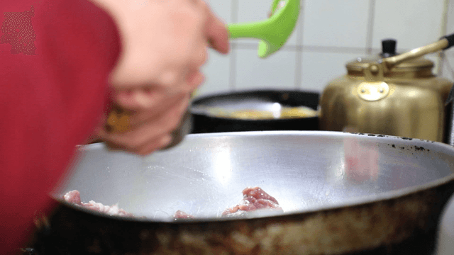 Cooking meat in a pan with a spatula