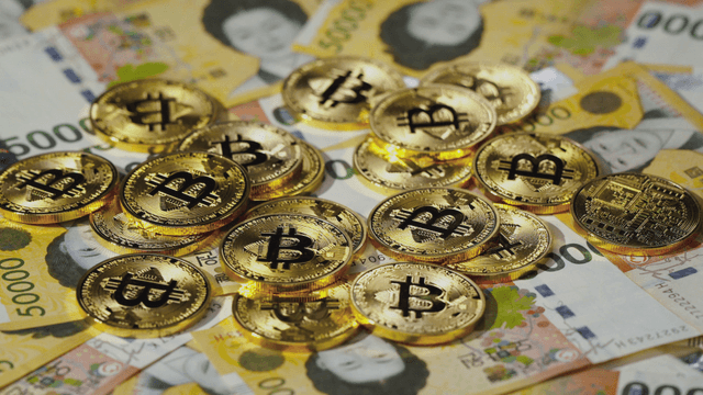 Bitcoin coins on Korean currency notes