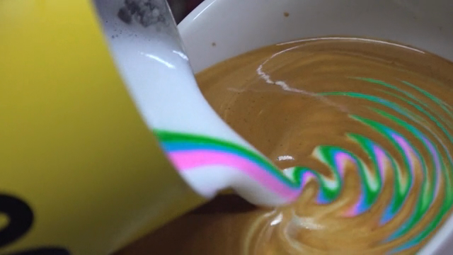 Colorful latte art being poured into coffee