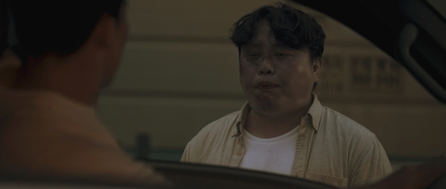 Man vomiting blood while looking into a car