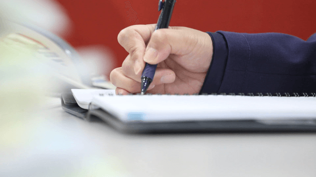 Person writing notes in a notebook