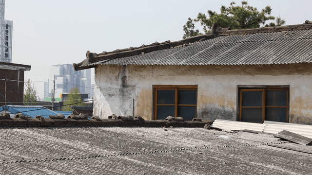 Old house with modern buildings in the background