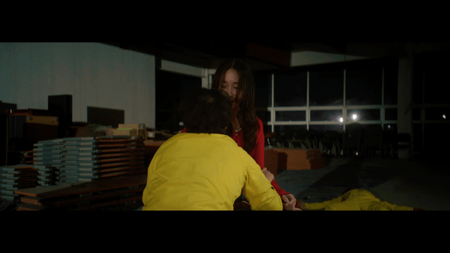 Two people in a dimly lit room