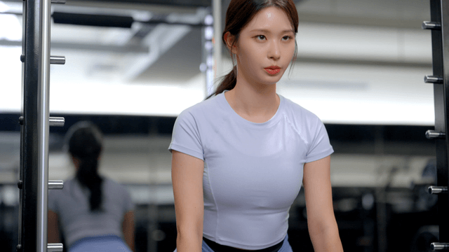 Young woman doing deadlift in gym