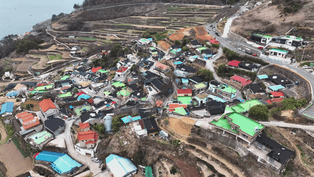 Terraced fields by the sea with a village