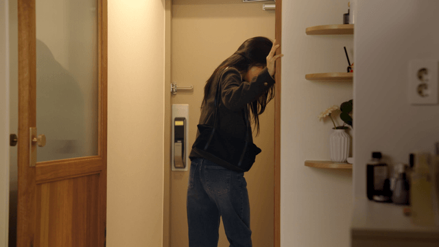 Couple at doorway with woman leaving in dark expression