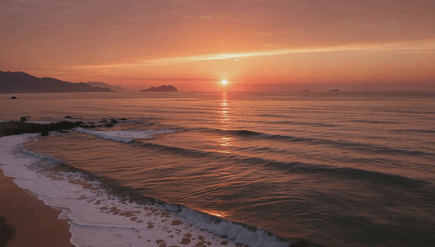 Serene beach with waves at sunset