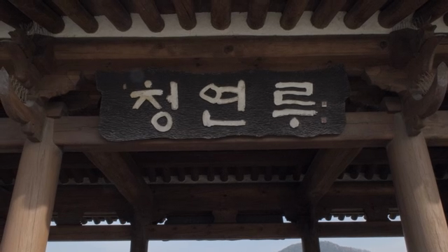 Traditional Korean pavilion with mountains