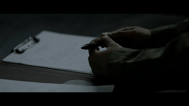 Hands holding a pen over documents