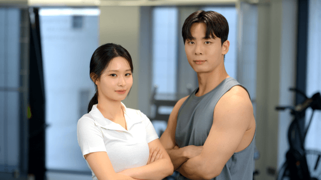 Confident couple posing with arms crossed at gym