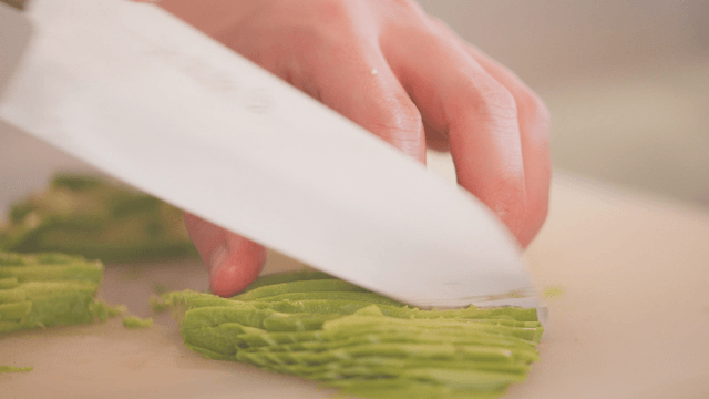 Hands delicately slicing an avocado