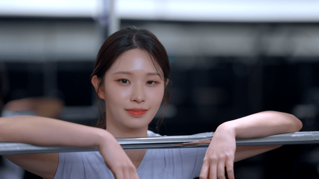 Young woman resting against a barbell at the gym