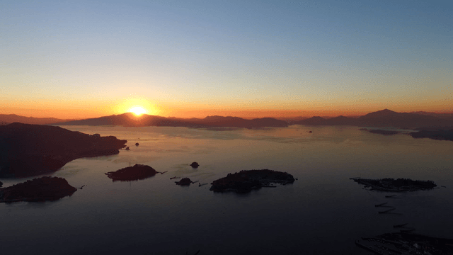Sunrise over a tranquil sea with islands