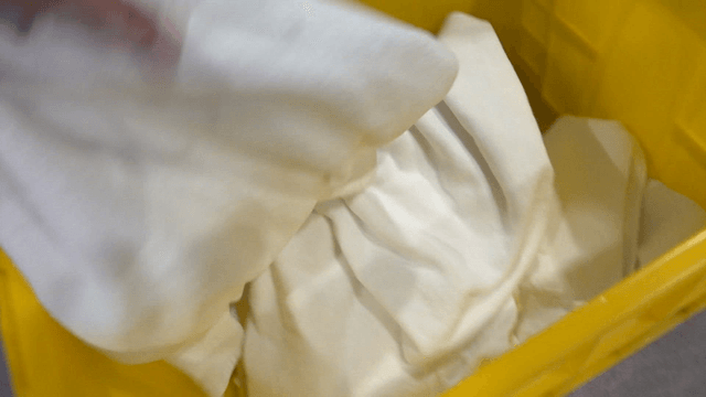 Yellow plastic box filled with white cloths