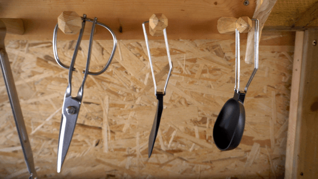 Various tools hanging on a wooden shelf