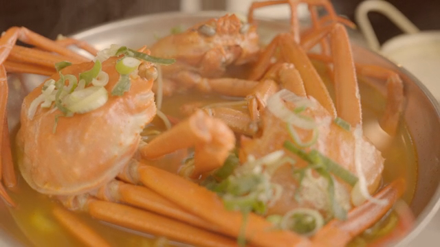 Steaming crabs in a pot with garnish