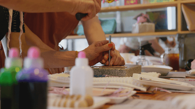 Hands working with a hammer on workshop table