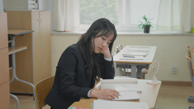 교실에서 공부하다 지루해하는 학생