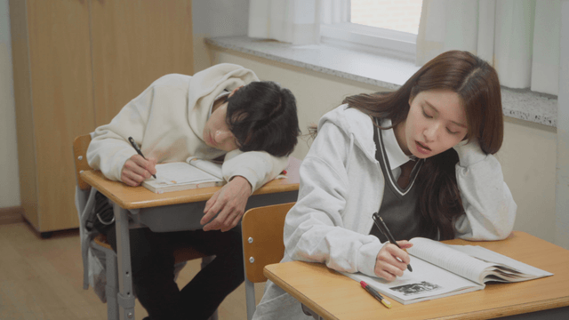 교복 위에 후드를 입고 피곤하게 공부하는 학생들