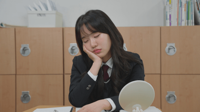 Student in a classroom looking tired