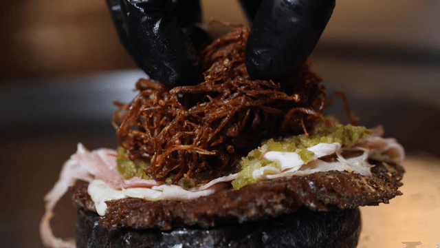 Gourmet burger being prepared with toppings