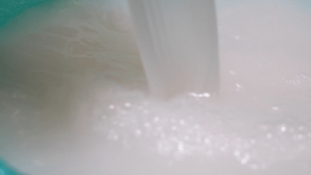 Milky rice water poured into bowl